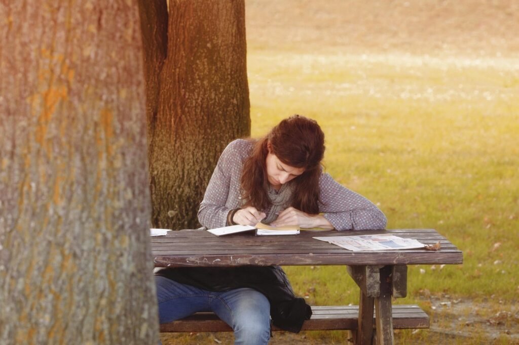 Una mujer escribiendo en un cuaderno, en reflexión